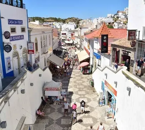 Taxi de Huelva a Albufeira: la calle empedrada del casco antiguo, con las casas blancas y las tiendas