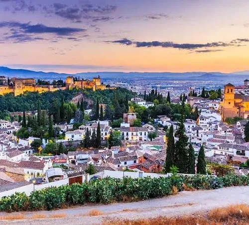 Taxi de Huelva a Granada: la Alhambra iluminada al anochecer, sobre el Albaicín