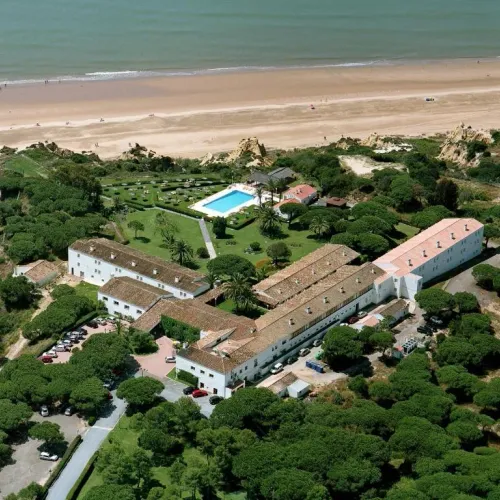 Taxi de Huelva al Parador de Mazagón, en Mazagón: vista aérea, entre pinos y con la playa al pie del acantilado