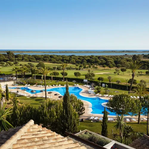 Taxi de Huelva al Precise Resort El Rompido, en El Rompido: vista aérea de la piscina, junto al campo de golf y la ría