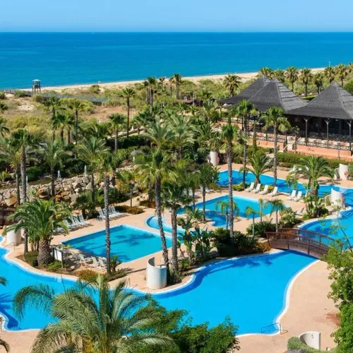 Taxi de Huelva al Puerto Antilla Grand Hotel, en La Antilla: vista aérea de las piscinas, con la playa detrás
