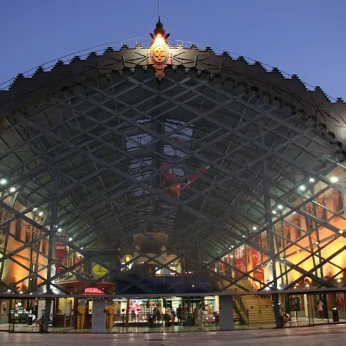 Taxi de Huelva a la estación de Plaza de Armas: la fachada acristalada de la estación, iluminada de noche