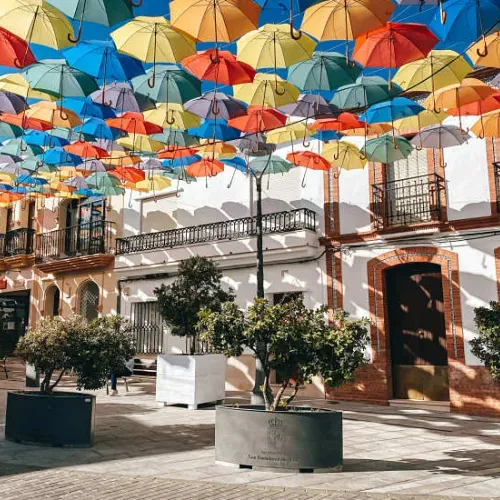 Taxi de Huelva a San Bartolomé de la Torre: la calle con los paraguas de colores