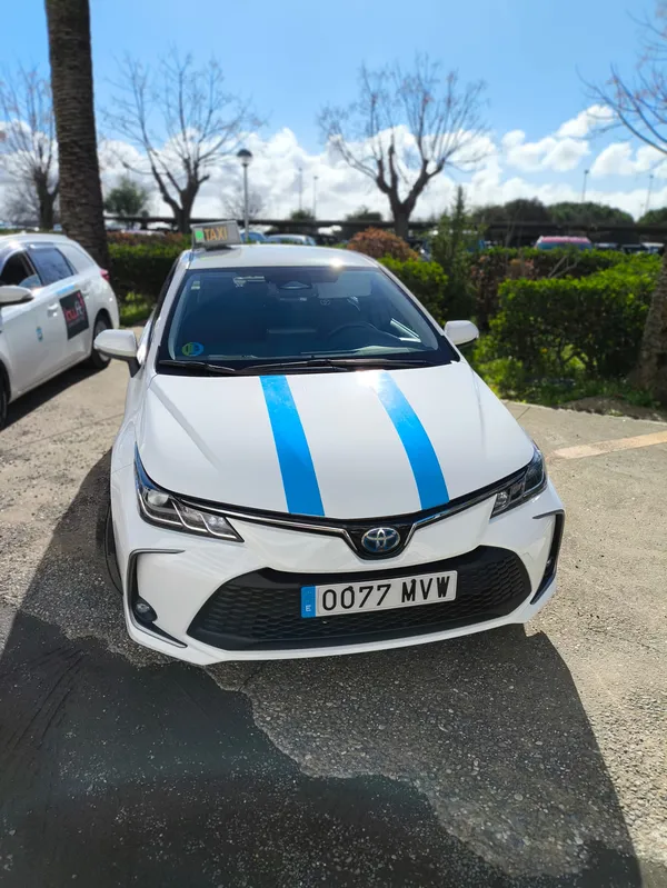 David Toscano y su taxi de Huelva, un Toyota Corolla Hybrid blanco con las dos bandas azules